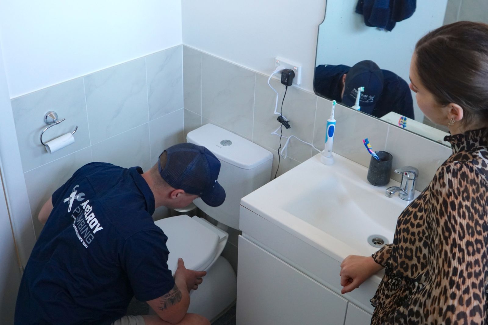 Plumber fixing a toilet cistern in a bathroom